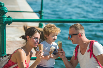 Summer vacation of happy family. Mother and father with son eat ice cream at sea. Child with father and mother. Family travel with kid on mothers or fathers day. Love and trust as family values.