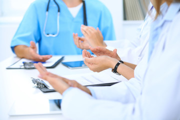 Group of doctors applauding at medical meeting. Close up of physician hands. Teamwork in medicine 