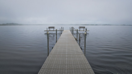 Dock with benches on foggy lake in Bemidji Minnesota