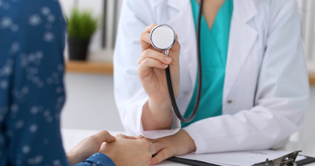Doctor with a stethoscope in the hand. Physician  is ready to examine her female patient. 