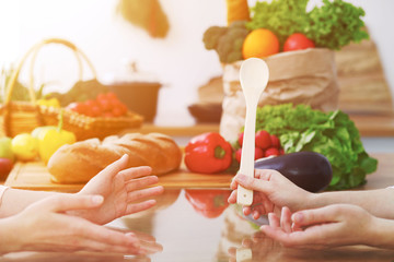 Closeup of human hands cooking in kitchen. Women discuss a menu. Healthy meal, vegetarian food and lifestyle concept