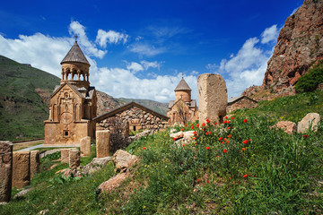 Noravank monastery complex built on ledge of narrow gorge. Sunny day in mountains. Tourist and...