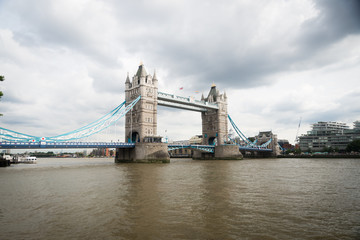 Fototapeta na wymiar London Bridge on a gloomy day in England near the thames river with murky water and tourists roaming about
