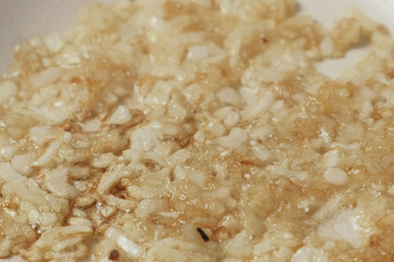 Close-up of onions fried in a pan until Golden brown.