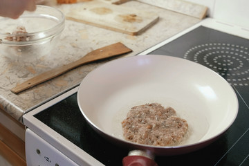 Close-up man's hands makes cutlets and fries it on the frying pan.