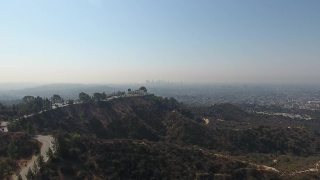 Griffith Observatory with drone flying towards downtown Los Angeles.