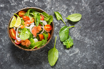 Selective focus Salmon Fresh green Salad with spinach, cherry tomatoes,baby spinach,  Concept for a tasty and healthy meal. Dark stone background. Top view. Close up.
