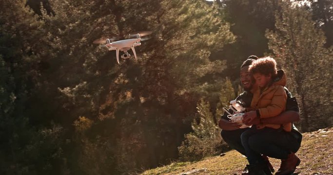 Father showing son how to fly drone with remote control