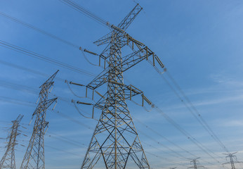 Electric poles and power lines in a  North American suburban area on a blue sky background 