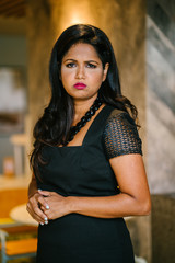 A business portrait head shot of a middle-aged, attractive and confident Indian Asian business woman. She looks worried, concerned, serious and upset. 