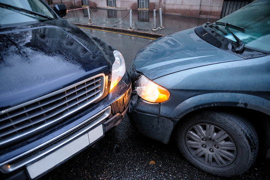 A Car Accident In The City In Rainy Weather Between A Minivan And An SUV. General Form.