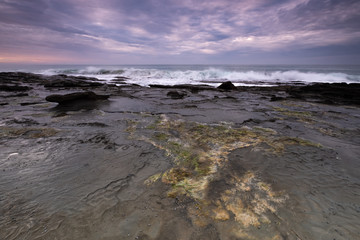 Coastline rock shelf alongside the iconic Great Ocean Road in Australia at sunrise