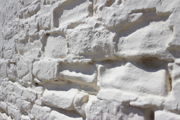 Close-up of a painted white brick wall outside.