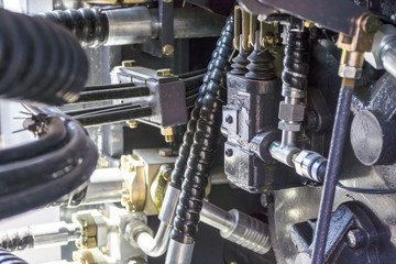 Close up of pipe system of hydraulic valves in agricultural machinery