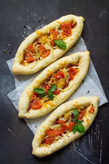 Pizza menu. Homemade Greek oval pizza with salami, tomato, onion and cheese. Top view flat lay background.