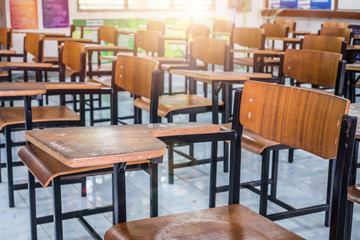 Lecture room or School empty classroom with desks chair iron wood for studying lessons in high school Thailand, interior of secondary education no kid teacher or young student with light flare