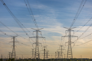 Electric poles and power lines in a  Canadian suburban area on a  sunset sky background