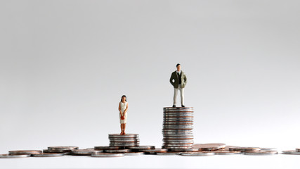 The concept of gender gap between employment and promotion. Miniature people standing on a pile of...