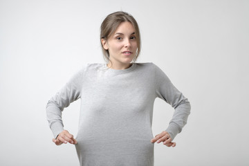 Losing weight concept. Caucasian thin woman showing that her dress is big for her.