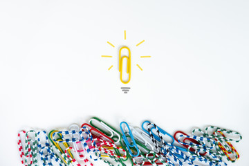 Minimal flat lay for group of paper clip with another individual paper clip standing alone on the...