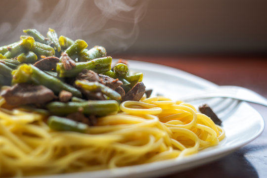 Steam from a Hot Dish with Delicious Pasta, Meat and Green Beans, Close-Up