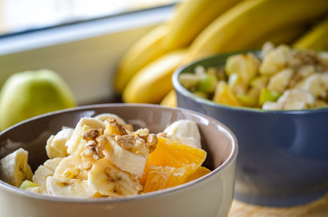 Healthy Breakfast Bowl: Oatmeal with Banana, Orange, Green Apple, Walnuts, Sesame and Chia Seeds