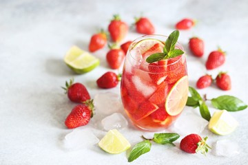 Strawberry infused water, coctail, lemonade or tea. Summer iced cold drink with strawberry, lemon and mint. Selective focus