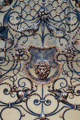 Fototapeta na wymiar Details, structure and ornaments of forged iron gate. Decorative ornamen with lions , made from metal