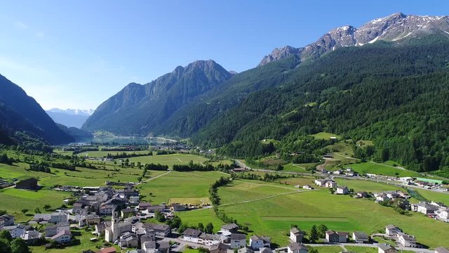 Cultivated fields in Val Poschiavo, panoramic view. Little alpine village and lake of Poschiavo