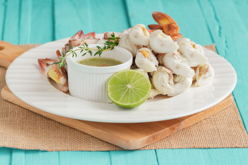 Steamed crab meat prepared for ready to eat with Thai style spicy dipping sauce on white plate on blue sea wood table with copy space for background or wallpaper. Delicious homemade seafood concept.