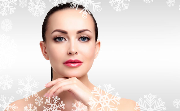 Pretty woman against a grey background with snowflakes