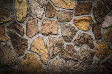 Wall built of natural stone with cement. Toned