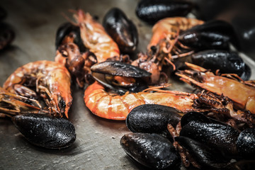 Seafood for frying on a metal background on a professional restaurant kitchen. Selective focus. Shallow depth of field. Toned