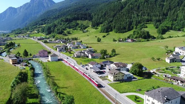 Red train of Bernina in Poschiavo city. Swiss Alps.