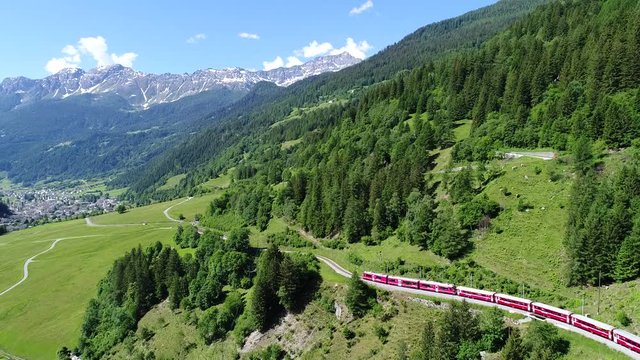 Bernina Express, red train in a forest. Val Poschiavo. Aerial view with drone