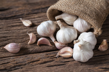 Garlic cloves and bulb on wooden background