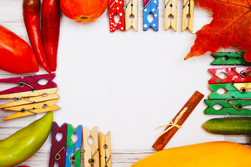 Vegetables and autumn leaves on a light wooden background with space for writing text, top view.