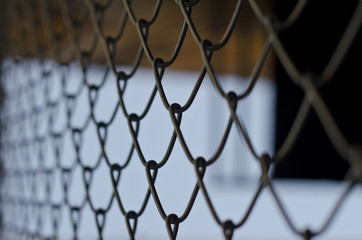 Fototapeta premium A view of the alley through the chain linked fence of a nice summer day. 