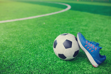 Fototapeta na wymiar Football and Sports shoes on artificial turf.
