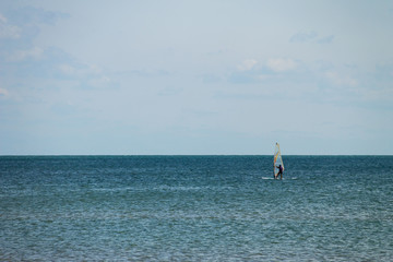 Naklejka premium Windsurfing. Surfer exercising in calm sea or ocean.