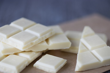 White chocolate pieces on gray background.