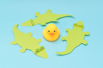 Trap concept, rubber duck is surrounded by crocodiles.