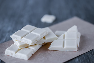 White chocolate pieces on gray background.