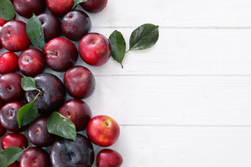 Fototapeta na wymiar Ripe juicy plums on wooden table