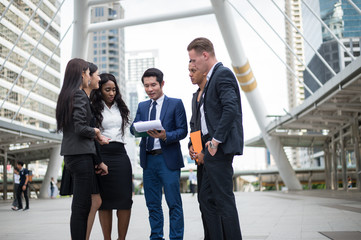 Group of business people standing in the city and discussing ideas for business future. multi culture of business people, African, Caucasian and Asian.