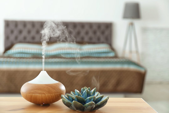 Aroma oil diffuser on table at home. Air freshener