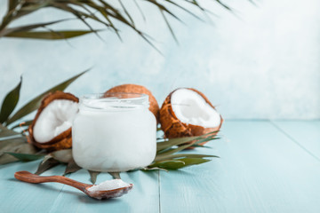 Coconut oil and coconuts on a bright pastel background.