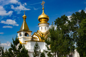 Fototapeta na wymiar Beautiful view of the temple of St. Seraphim of Sarov in Khabarovsk. Beautiful green lawn in the foreground. Religious architecture, buildings and traditions. Russia.
