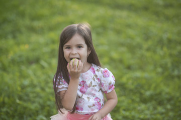 Fototapeta premium Girl eat apple on natural background, vitamin