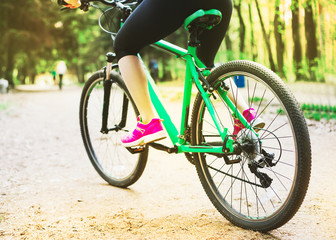 Naklejka premium Young Woman Riding Sport Mountaine Bicycle in Forest outside
